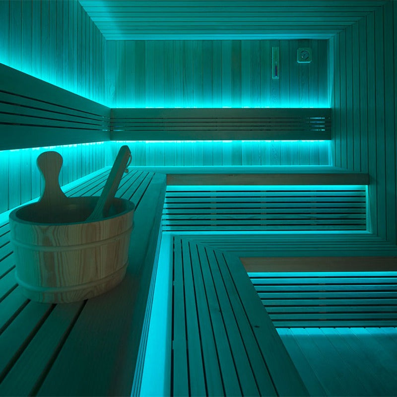 Interior view of the AWT The Cube X7-r pro Hemlock Outdoor sauna 300×235 cm with two-tier benches, infusion bucket and intense blue LED ambient lighting